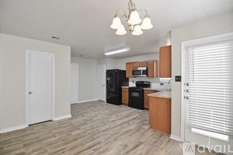 A kitchen with a black fridge and white cabinets.