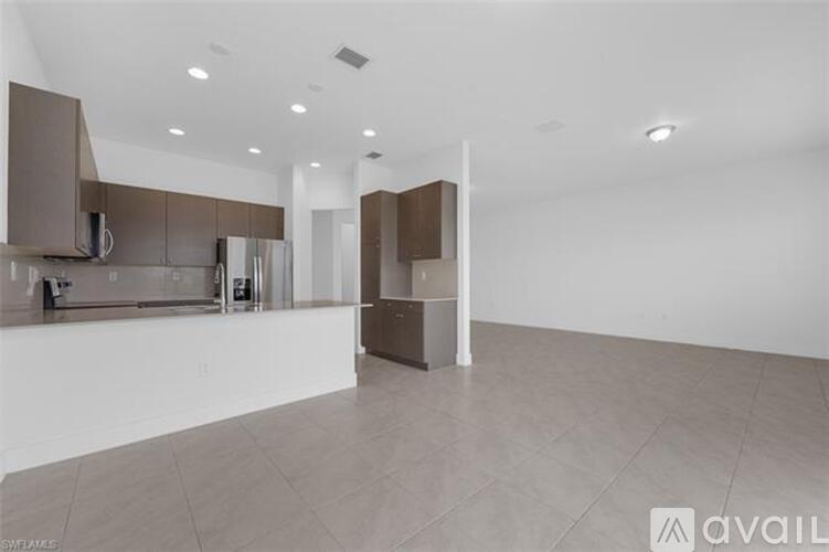 A spacious kitchen with brown cabinets and a white countertop.