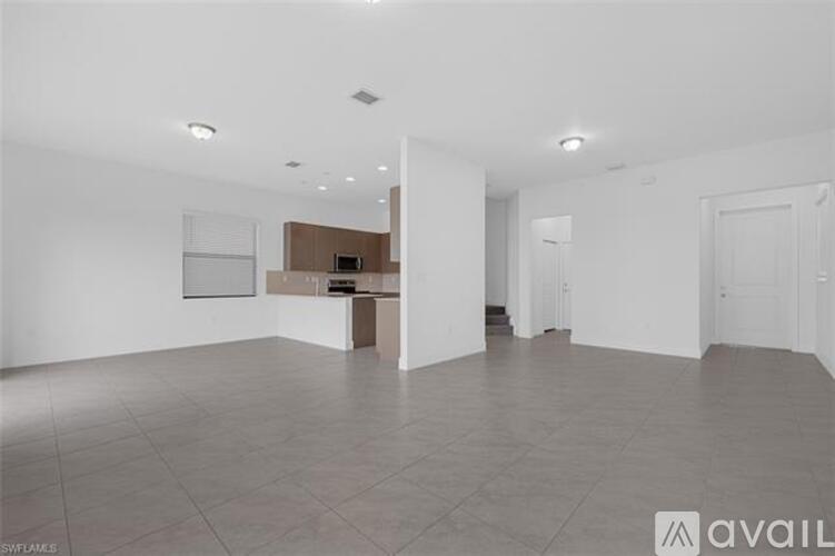 A spacious room with a tiled floor and white walls.