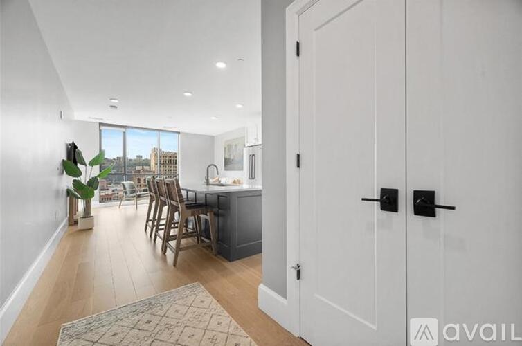 A kitchen with white cabinets and a view of the city.
