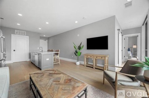 A living room with a wooden coffee table and a grey sofa.
