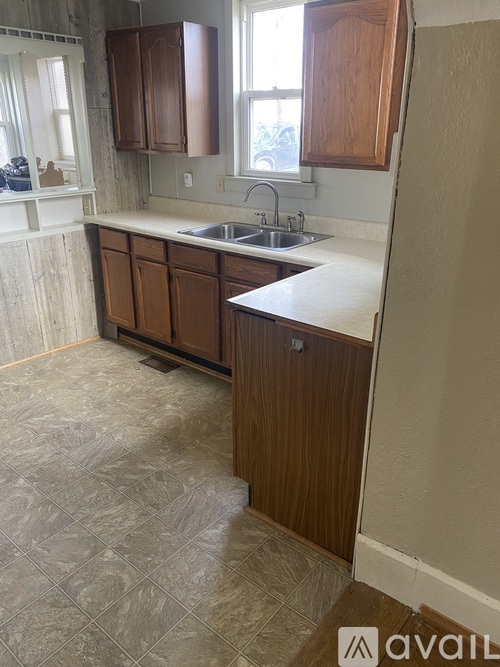 A kitchen with wooden cabinets and a tiled floor.