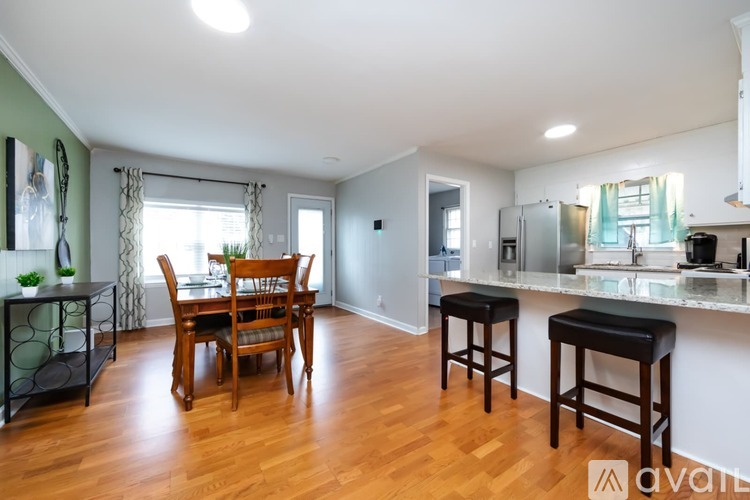 A kitchen with a dining table and chairs in the middle of the room.