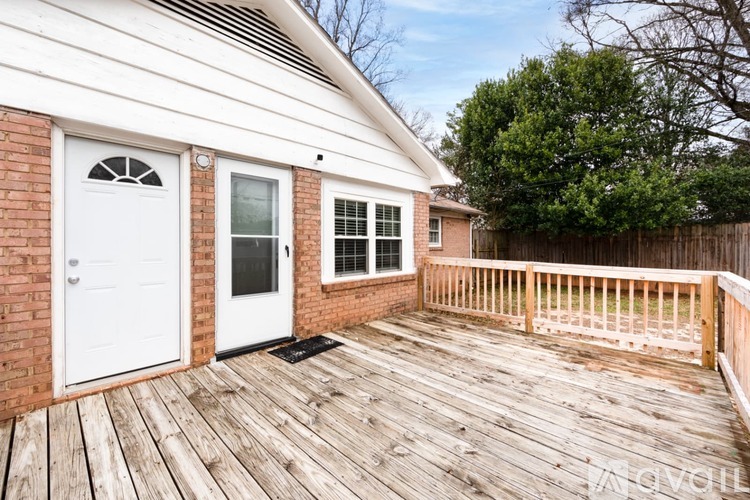A wooden deck with a white door and windows.