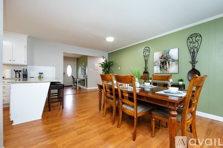 A dining room with a table set for six with chairs around it.