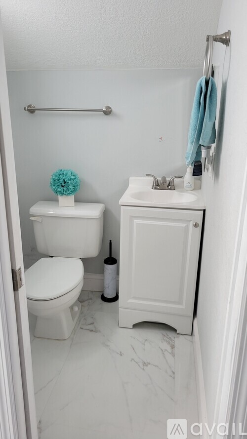 A white toilet and sink in a small bathroom.