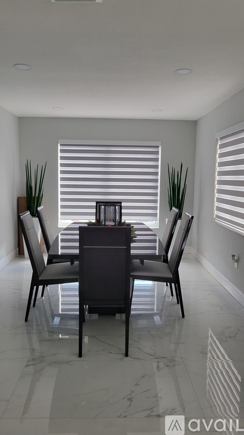 A dining room with a table and chairs.