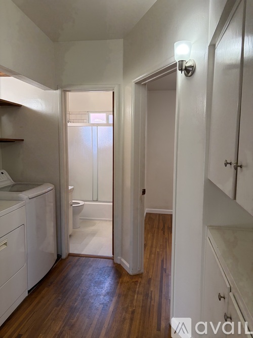 A small bathroom with a toilet, sink, and wooden floors.