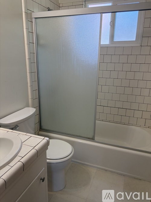 A white toilet sits next to a white sink in a bathroom.
