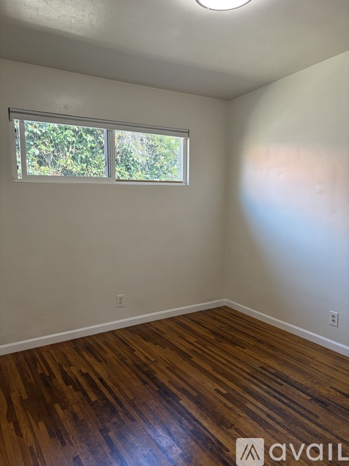 A room with wooden floors and a window.