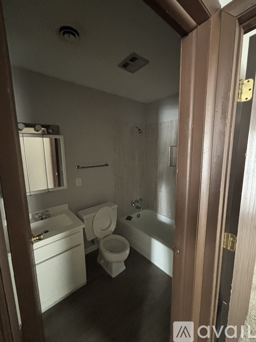 A bathroom with a toilet, sink, and bathtub.