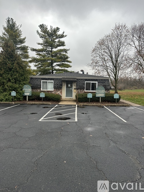 A parking lot with a building and a sign that says "AVAILABLE".