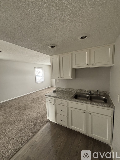A kitchen with white cabinets and a granite countertop.