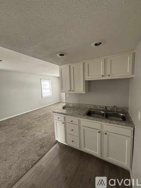 A kitchen with white cabinets and a granite countertop.