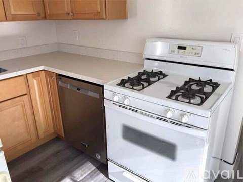 A white stove and oven in a kitchen with wooden cabinets.