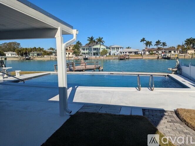 A pool area with a white canopy and a clear blue sky in the background.