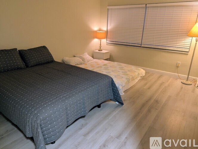 A bedroom with a large bed and two lamps.