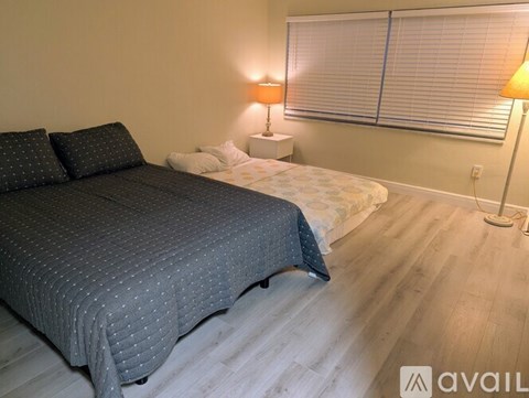 A bedroom with a large bed and two lamps.