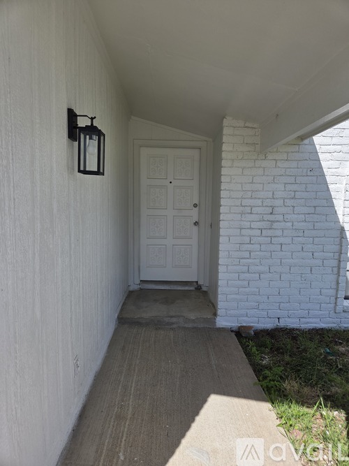 A white door is at the end of a hallway.