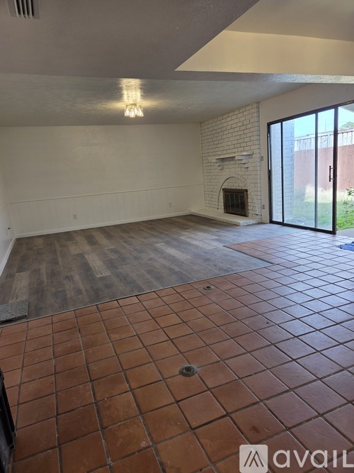 A room with a fireplace and tiled flooring.