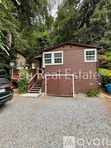 A brown house with a car parked in front of it.