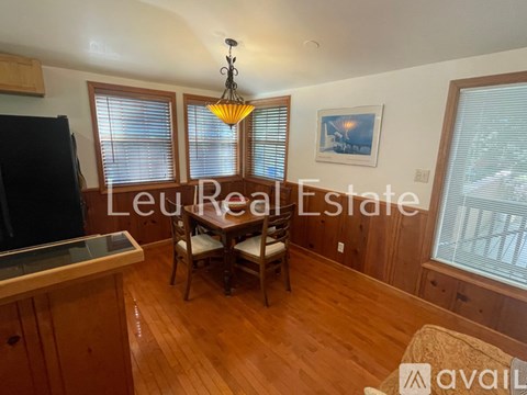 A kitchen with wooden floors and a dining table with chairs.