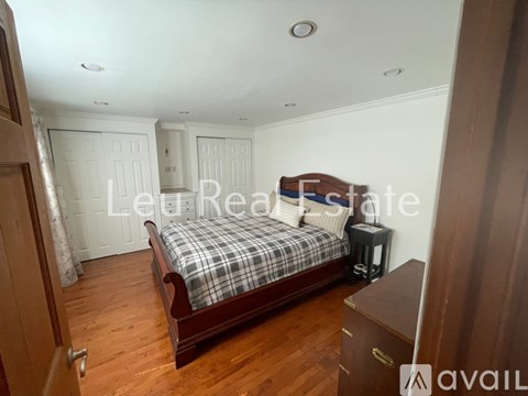A bedroom with a bed, nightstand, and wardrobe.
