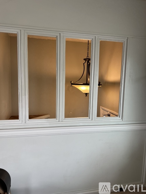 A white cabinet with a light hanging from it.