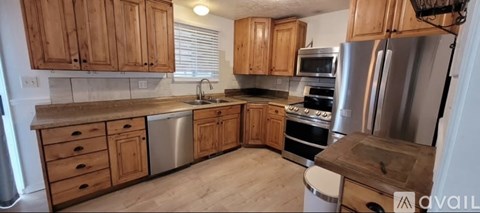 A kitchen with wooden cabinets and stainless steel appliances is available.