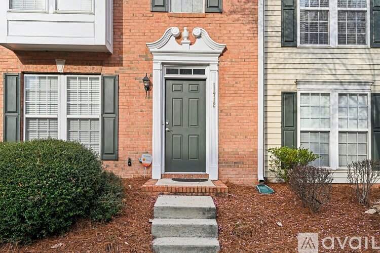 A house with a grey door and a brick wall.