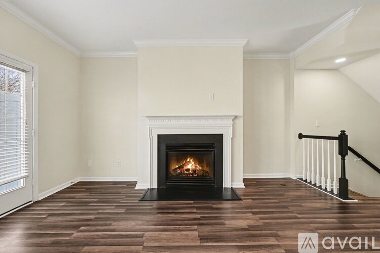 A living room with a fireplace and wooden floors.