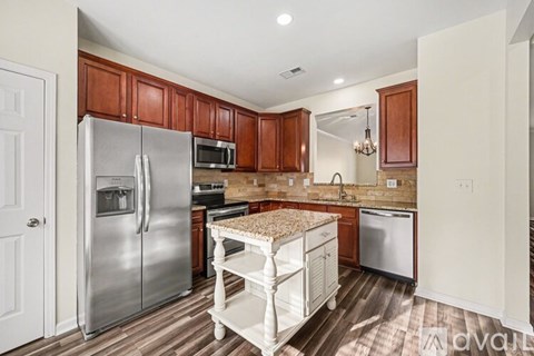 A kitchen with wooden cabinets and a granite counter top.