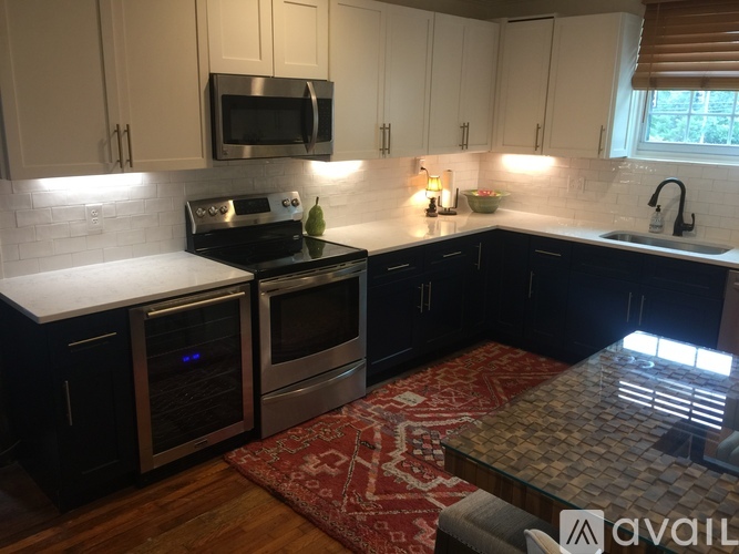A kitchen with black cabinets and a white countertop.
