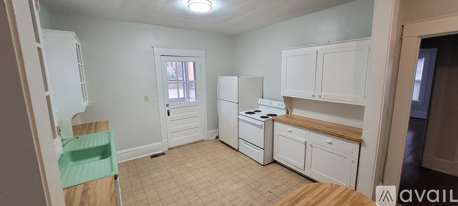 A kitchen with white appliances and cabinets.