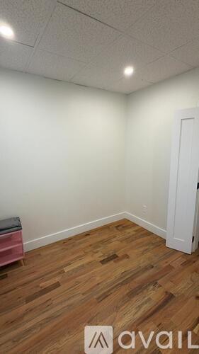 A room with wooden flooring and a white door.