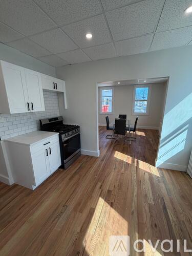A kitchen with white cabinets and a black stove top oven.