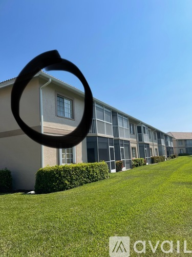 A building with a lawn in front and a sign that says "avail" in the foreground.