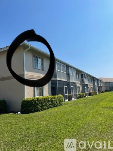 A building with a lawn in front and a sign that says "avail" in the foreground.