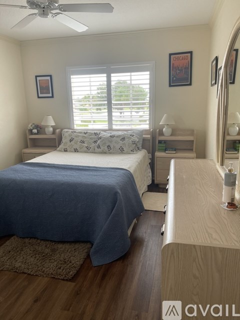 A bedroom with a bed, nightstands, and a window.