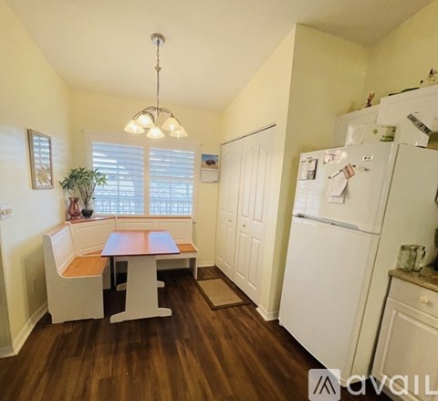 A kitchen with a table and chairs in front of a window.