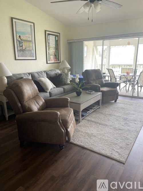A living room with a brown leather couch and a grey sofa.