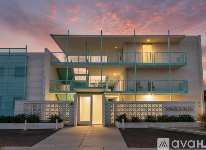 A modern building with a glass facade and a balcony with a railing.