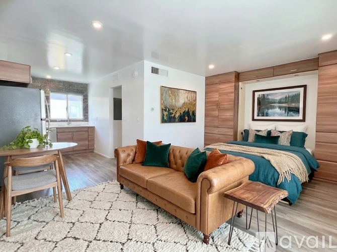 A living room with a tan couch and a white rug.