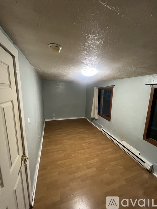 A room with wooden floors and a white door.