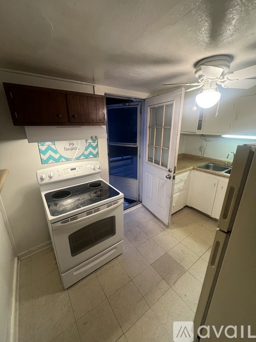 A kitchen with a white oven and a white door.