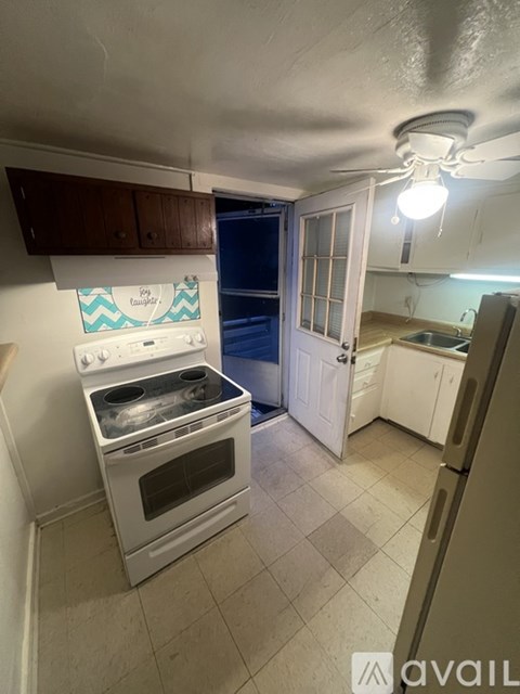 A kitchen with a white oven and a white door.