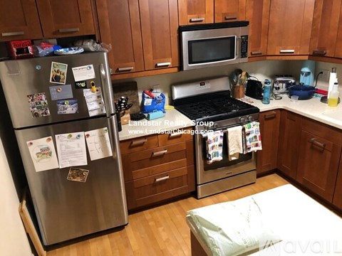 A kitchen with a refrigerator, stove, and microwave.