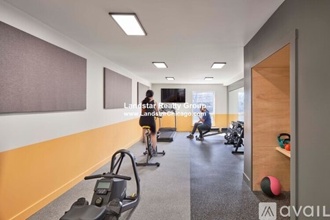 A gym with exercise equipment and a person on a stationary bike.