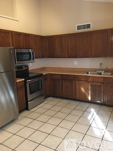A kitchen with a stainless steel refrigerator, oven, and microwave.