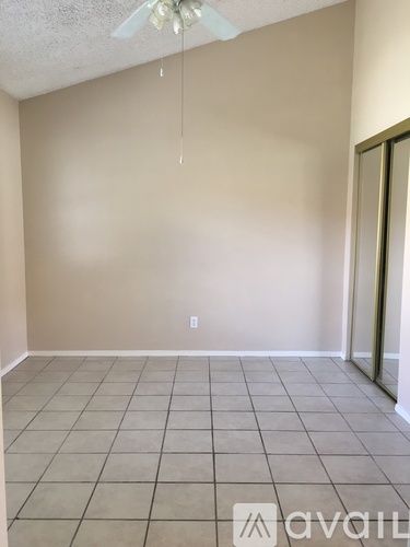 A room with beige walls and a ceiling fan.
